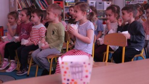 Dzieci jedzą popkorn i oglądają film