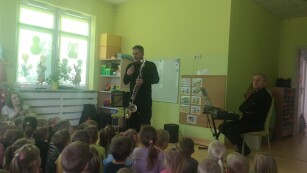 pan muzyk pokazuje dzieciom klarnet basowy