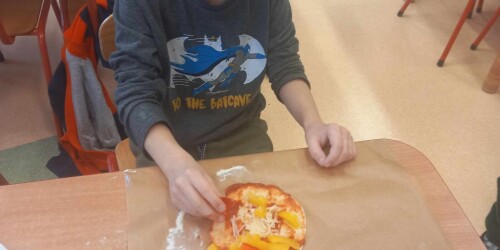 Chłopiec ozdabia pizzę