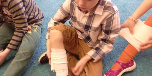 chłopiec zakłada bandaż