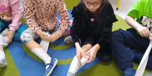 dziewczynki bandażują nogę
