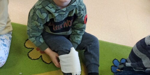 chłopiec bandażuje nogę