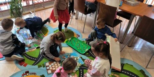 dzieci grają w gry planszowe w bibliotece