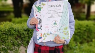 dziewczynka prezentuje dyplom za przegląd Chrońmy naturę